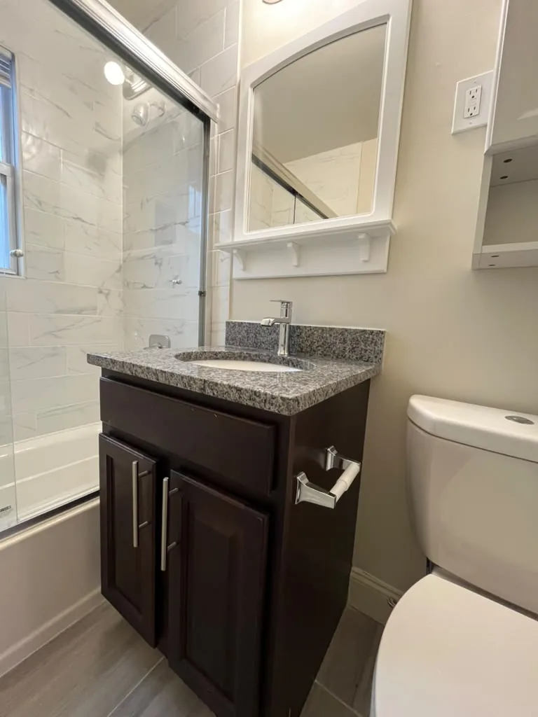 Bathroom with marble wall tile and dark vanity