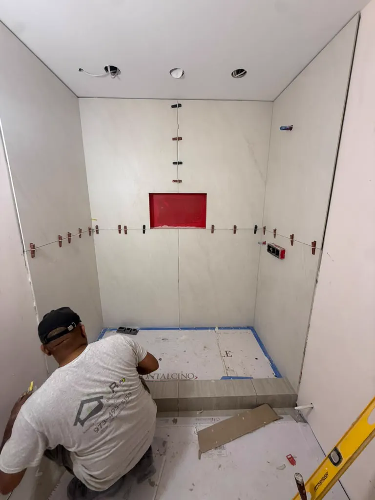 Large format marble wall tile going up around a shower niche