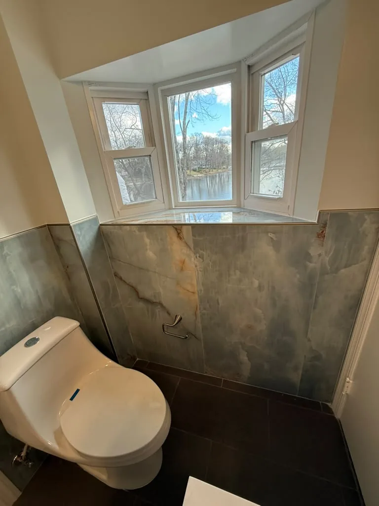 Bathroom with veined stone wall tile and dark floor