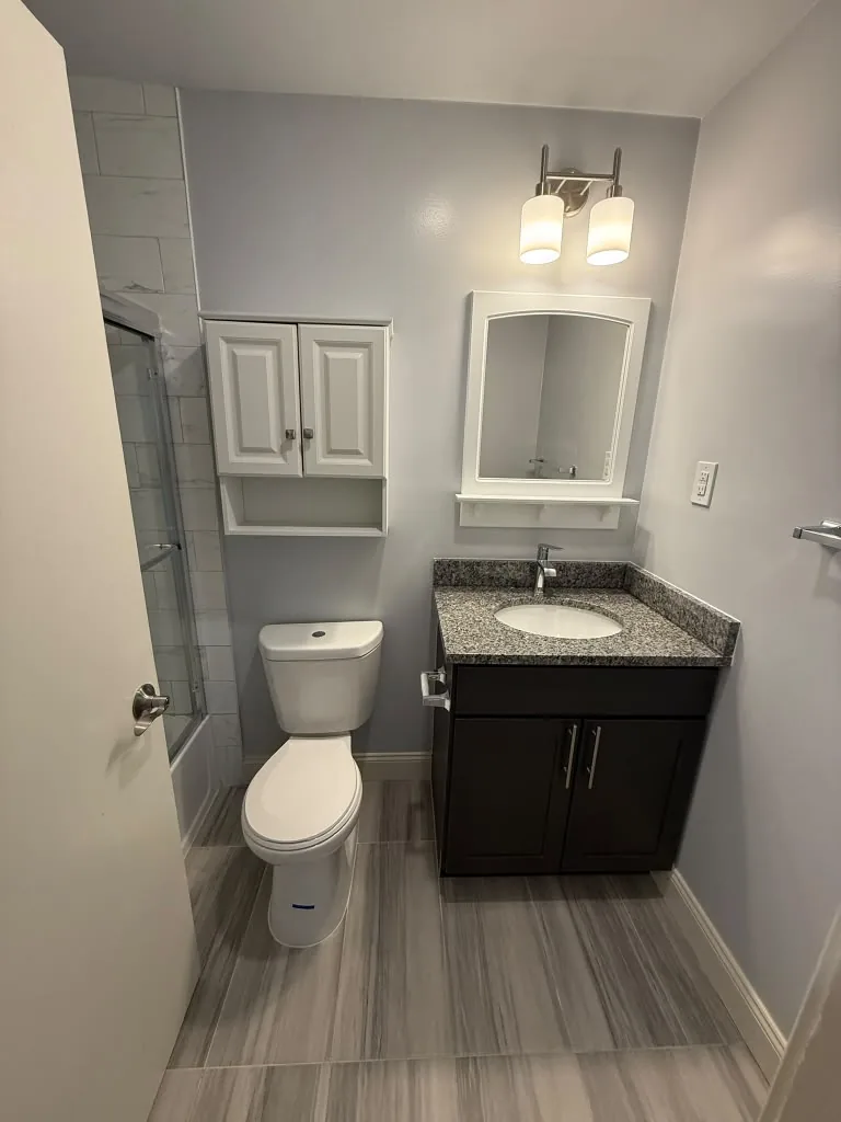 Bathroom vanity with framed mirror and sconce lighting