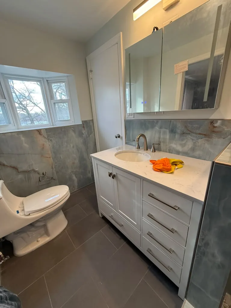 Bathroom with white double vanity and stone wall tile