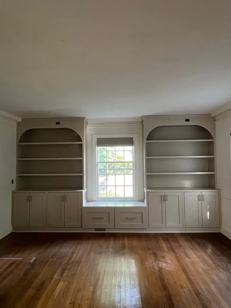 Pair of arched built-in bookcases flanking a window