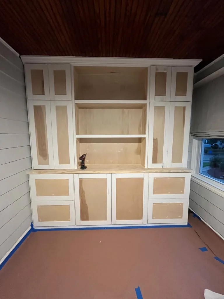 Built-in cabinet wall with paneled doors mid-installation