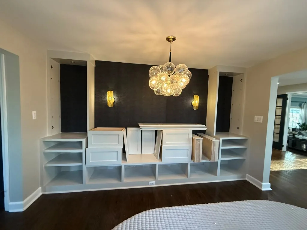 Built-in media wall and cabinetry under a chandelier