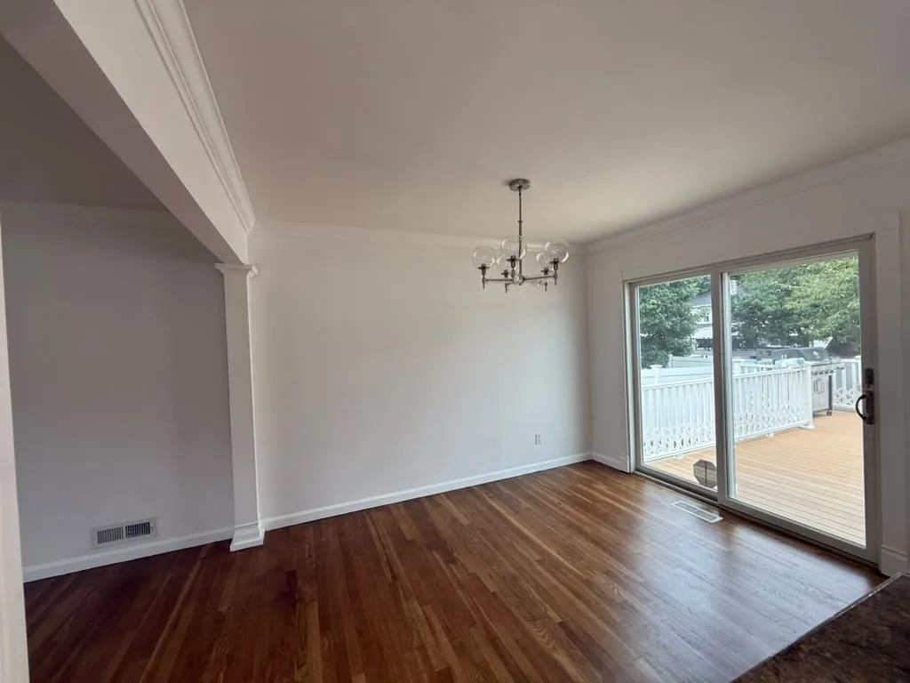 Dining area with chandelier, fresh paint and hardwood floors