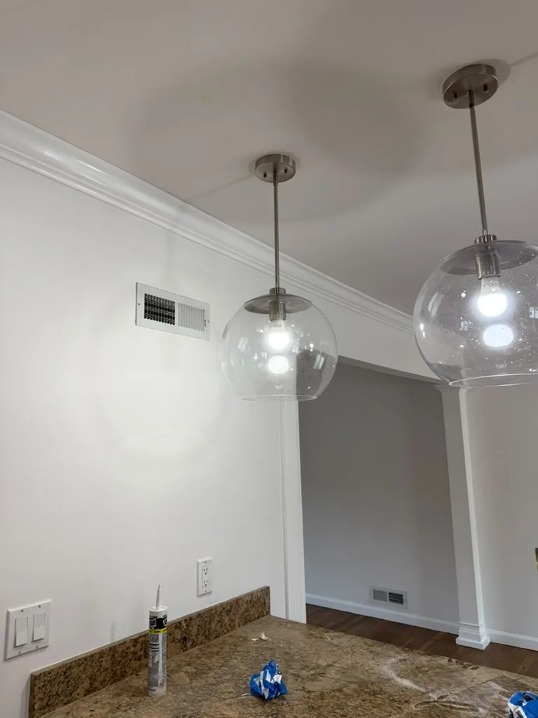 Dining area with glass globe pendant lights and stone counter