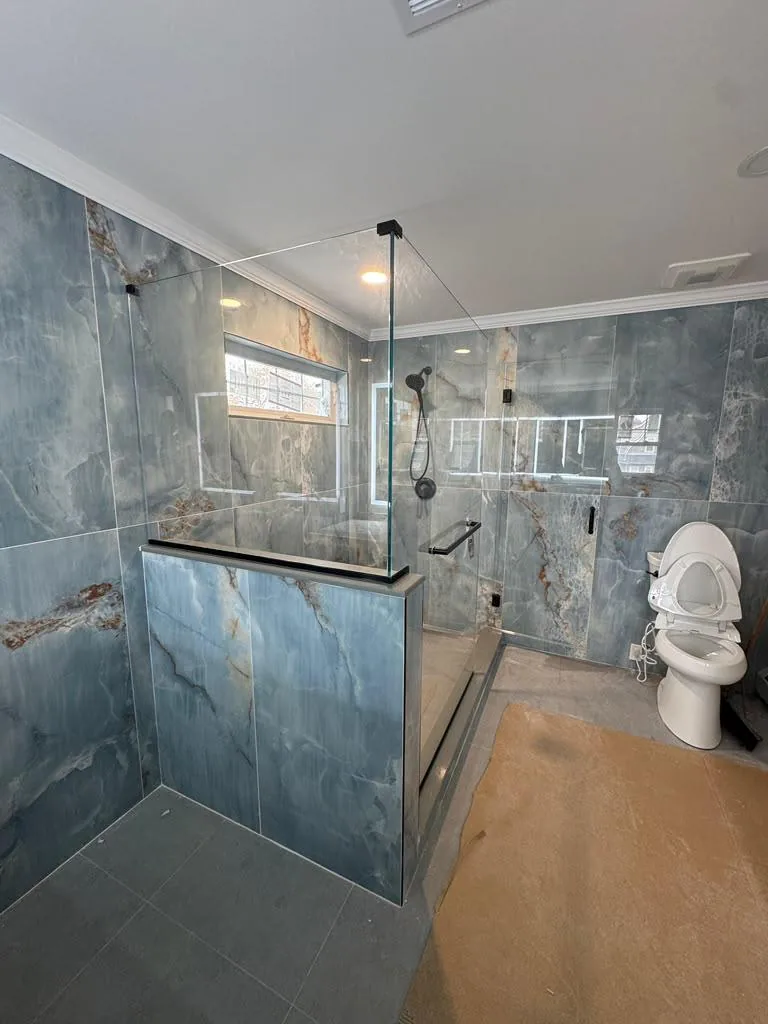 Glass panel enclosure on a blue stone walk-in shower