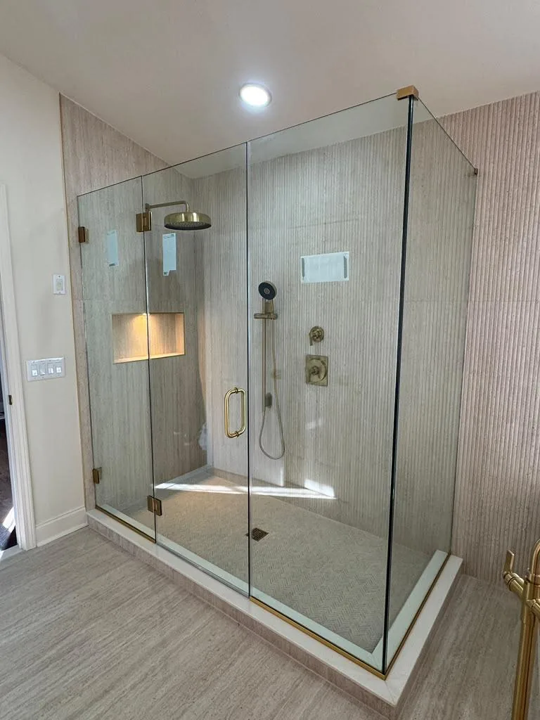 Large frameless glass enclosure with gold hardware