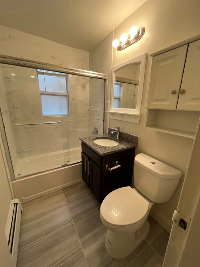 Glass shower enclosure with vanity and framed mirror