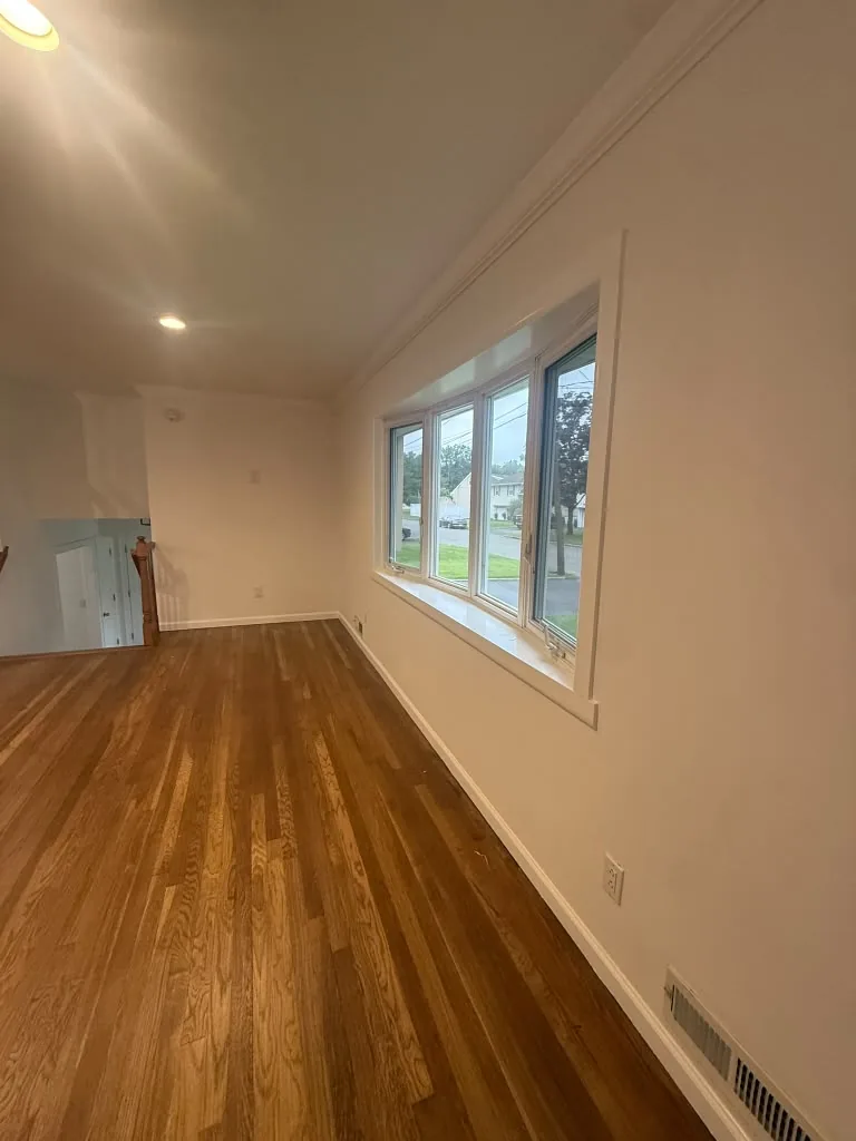 Refinished hardwood floors in a freshly painted room