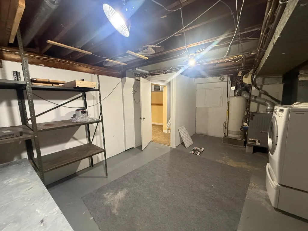 Unfinished basement with exposed joists and concrete floor