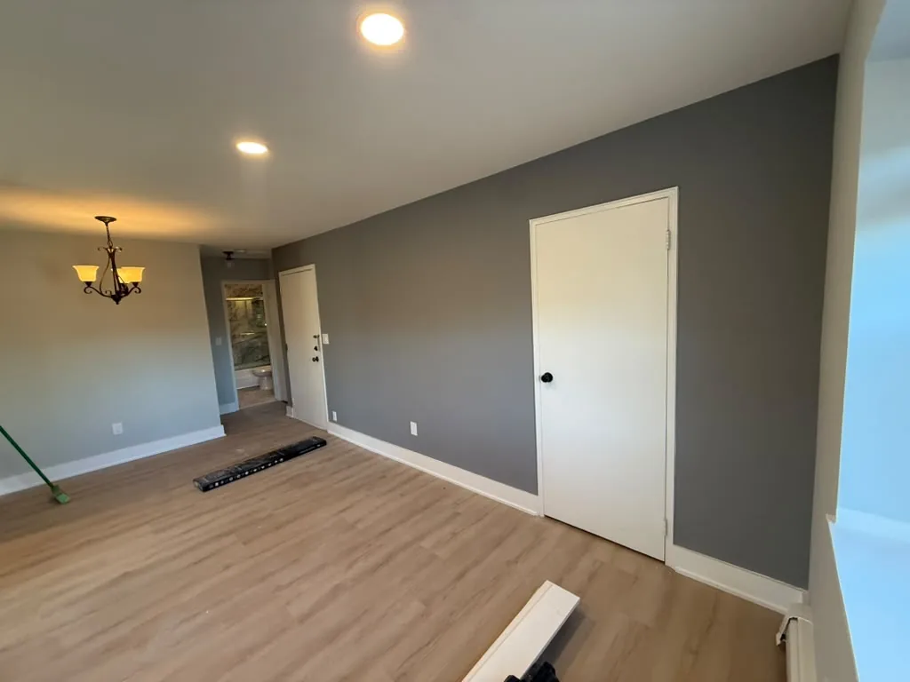 Room with gray walls, chandelier and vinyl plank flooring