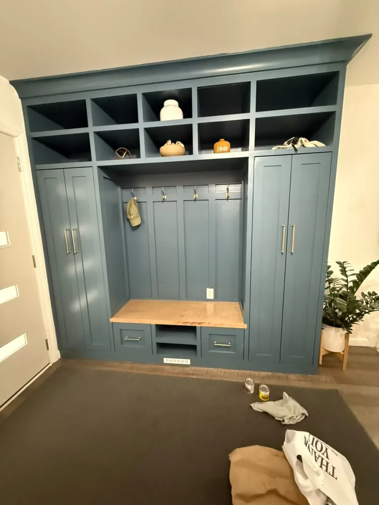 Blue mudroom cabinetry with butcher block bench
