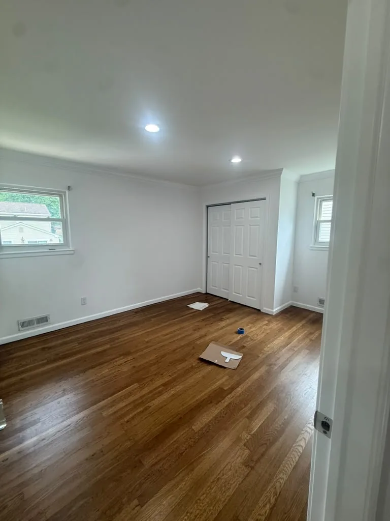Empty room with refinished hardwood floors