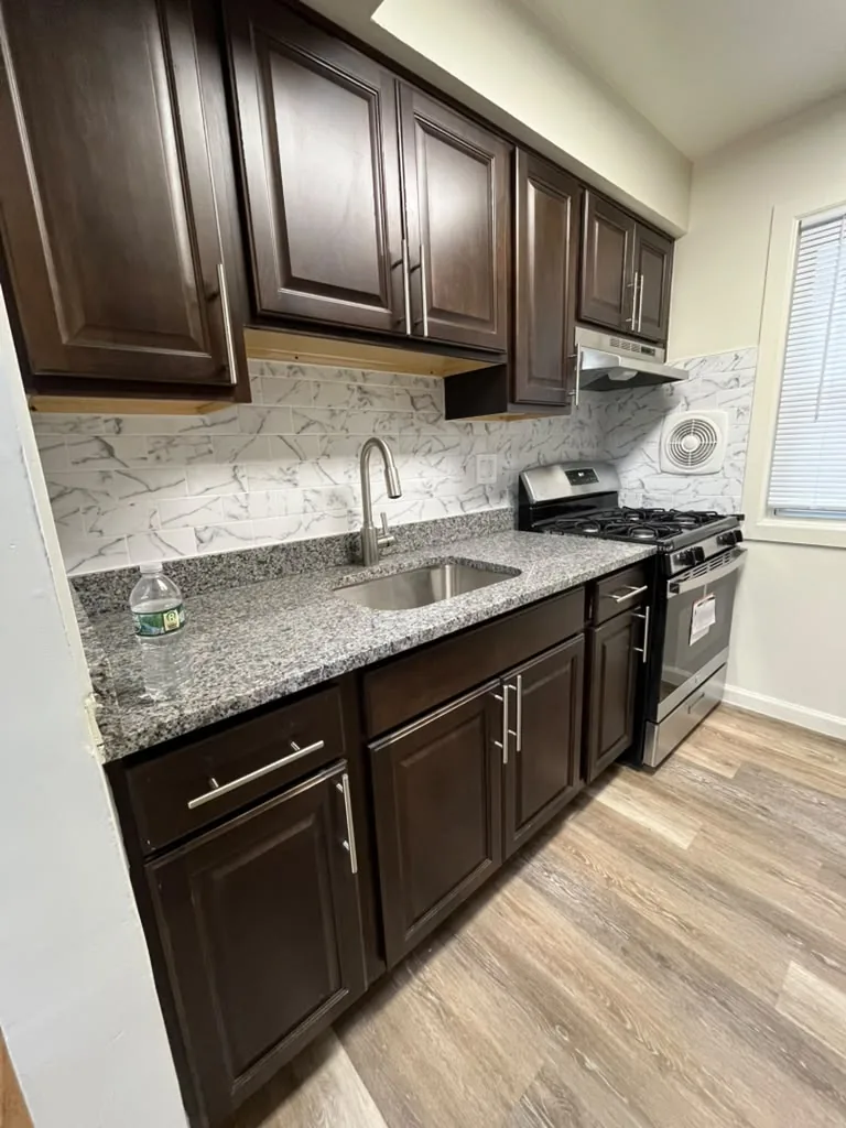 Wide view of espresso kitchen with granite counters and stainless range