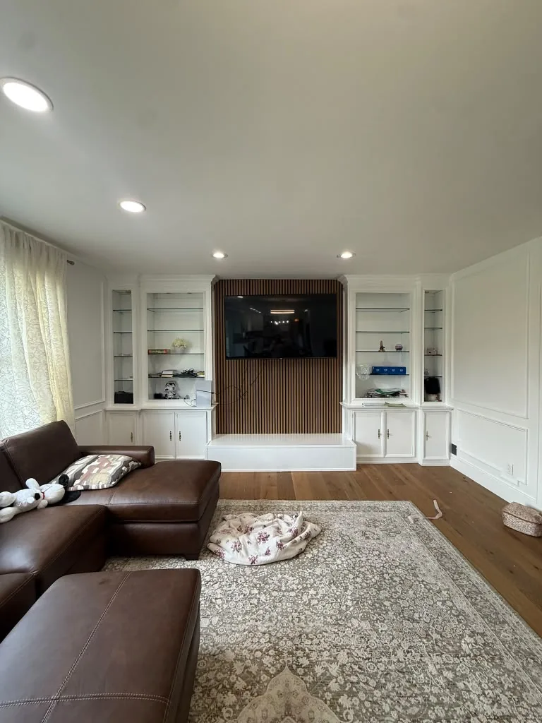 Living room with custom white built-ins framing a mounted television