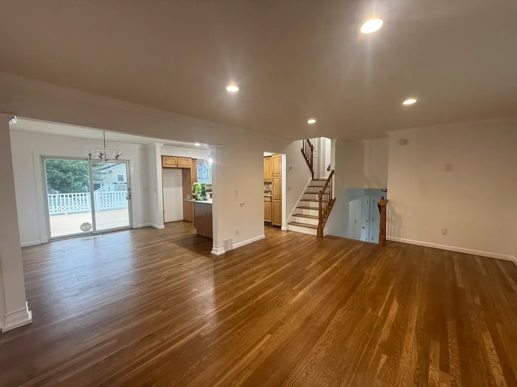Open living space with refinished hardwood floors and fresh trim