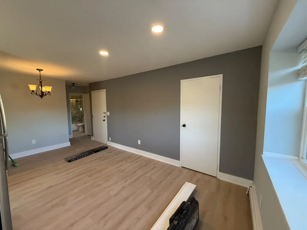 Warm toned living room with chandelier and refinished floors