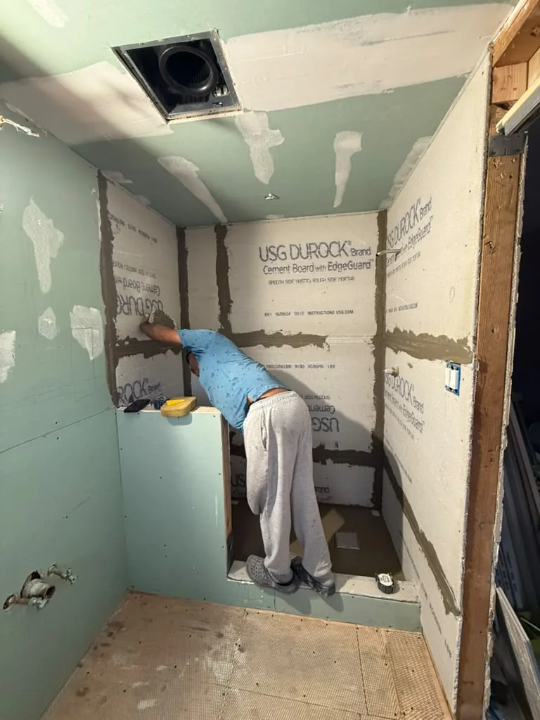 Waterproofing membrane being applied to shower walls before tile