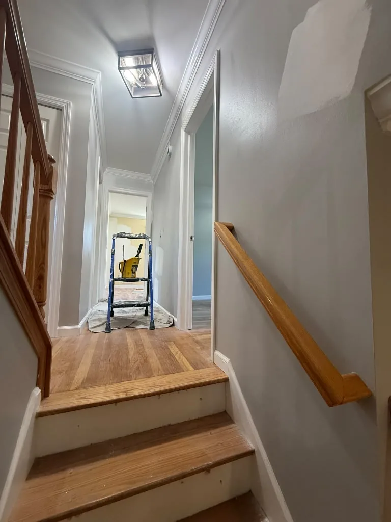Refinished staircase with wood handrail and painted risers